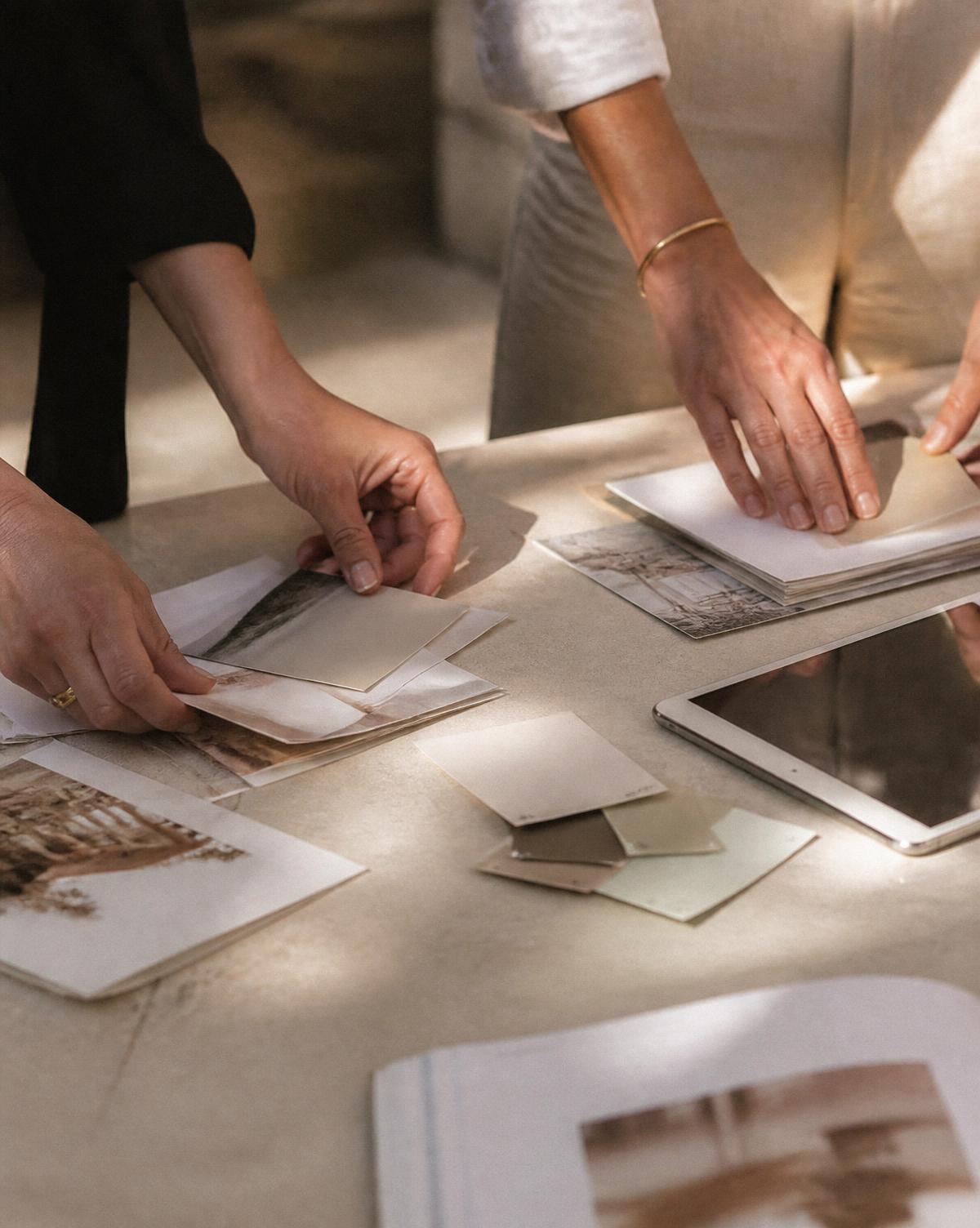 Two people arranging printed campaign materials on a limestone table during event setup