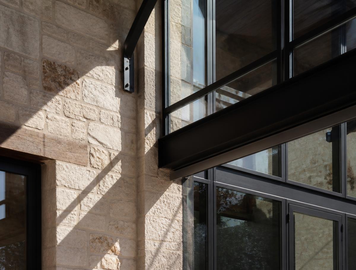 Warm San Antonio limestone meeting dark steel and glass in afternoon light